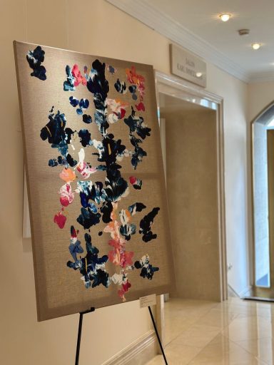 Abstrakte Malerei mit blauen, pinken und weißen Farbtupfern auf einem goldenen Hintergrund.