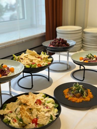 Vielfältige Salate und kleine Gerichte auf stilvollen Tellern, serviert auf Tischen.